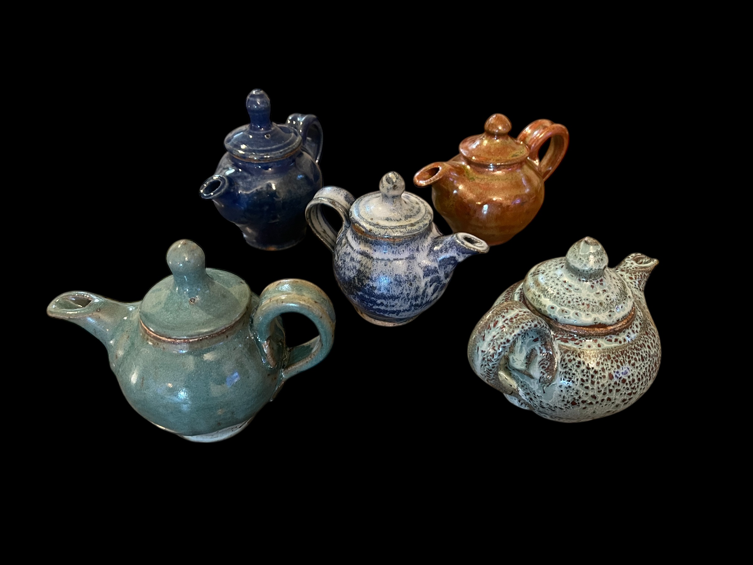 Five miniature teapots in various glazes